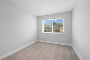 An empty room with white walls and a window