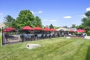 Falls Church apartment for rent - A pool surrounded by red umbrellas and a black fence at Tysons Glen Apartments and Townhomes, Virginia
