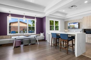 A kitchen with a bar area and a dining table.