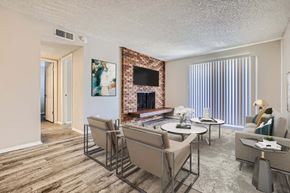 Colorado Springs apartment for rent - A living room with a fireplace and a dining table.