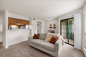 Overland Park apartment for rent - A living room with a grey couch and a brown pillow.