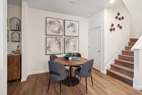 Aurora townhouse for rent - A dining room with a table set for two and a staircase in the background.