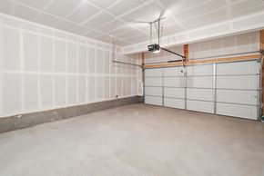 Aurora townhouse for rent - A spacious garage with a white ceiling and a light hanging from the ceiling.