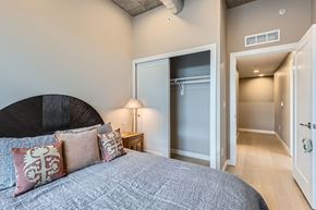 Denver apartment for rent - A bedroom with a large bed and a lamp on a nightstand.