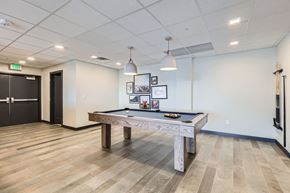 Denver apartment for rent - A room with a pool table and a bench.