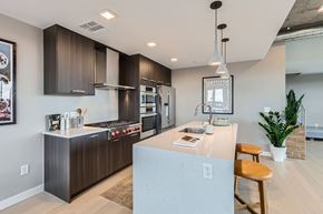 Denver apartment for rent - A modern kitchen with dark brown cabinets and a white island.
