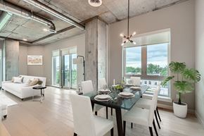 Denver apartment for rent - A modern dining room with a glass table and white chairs.