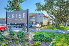 Carrollton apartment for rent - A sign for Arise Carrollton stands in front of a building.
