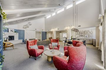 Englewood apartment for rent - A living room with red chairs and a grey carpet.