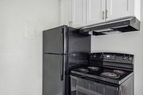 Colorado Springs apartment for rent - a kitchen with a stove refrigerator and white cabinets