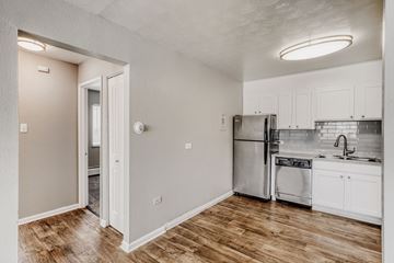 Denver apartment for rent - A kitchen with white cabinets and a wooden floor.