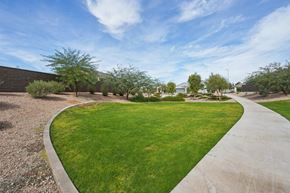 Casa Grande apartment for rent - A curved concrete pathway leads through a grassy area with trees.