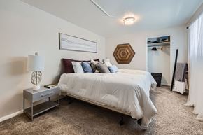 Denver apartment for rent - A bedroom with a bed, nightstand, and a painting on the wall.