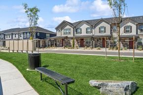 Aurora townhouse for rent - A park with a bench and a trash can in front of apartment buildings.