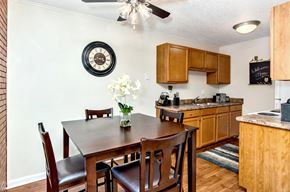 Colorado Springs apartment for rent - A kitchen with a table and chairs in the foreground and a clock on the wall.