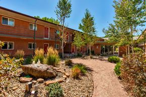 Colorado Springs apartment for rent - A courtyard with a rock in the middle and a building in the background.