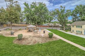 Colorado Springs apartment for rent - A park with a tree, benches, and a playground.