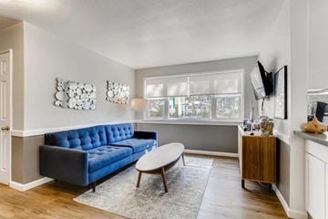 Colorado Springs apartment for rent - A living room with a blue couch and a wooden coffee table.