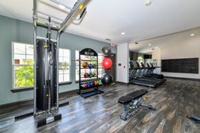 Jacksonville apartment for rent - A gym with a variety of equipment including a treadmill, a weight machine, and a rowing machine.