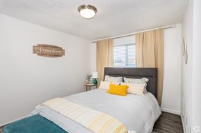 Englewood apartment for rent - A bedroom with a bed, nightstand, and a sign on the wall.