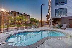 South Jordan apartment for rent - A swimming pool in a residential area with a sunset in the background.