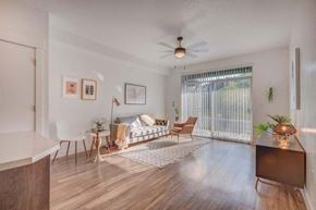 South Jordan apartment for rent - A living room with a couch, chairs, and a television.