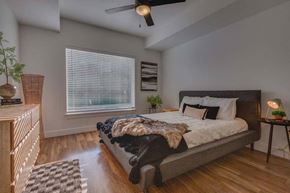 South Jordan apartment for rent - A bedroom with a bed, a ceiling fan, and a window with blinds.