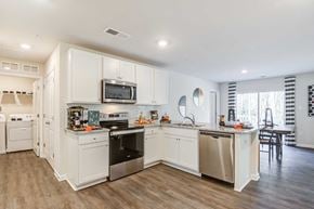 Salisbury apartment for rent - a large kitchen with white cabinets and stainless steel appliances