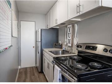 Denver apartment for rent - A kitchen with a stove top oven and a refrigerator.