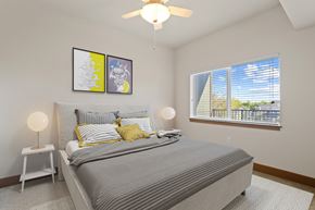 Fort Collins apartment for rent - A bedroom with a large bed and a ceiling fan.