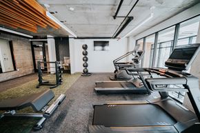 Salt Lake City apartment for rent - a gym with treadmills and other exercise equipment in a building with windows