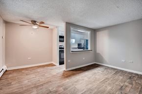 Denver apartment for rent - an empty living room with wood floors and a ceiling fan
