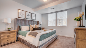Payson apartment for rent - A bedroom with a large bed, a dresser, and a nightstand.