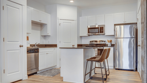 Payson apartment for rent - A kitchen with white cabinets and a wooden floor.