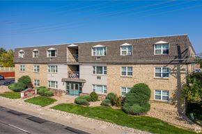 Englewood apartment for rent - A large building with a grey roof and a balcony on the second floor.