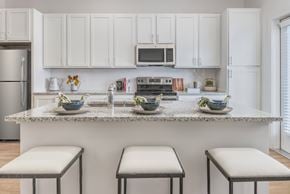 Indian Land apartment for rent - A kitchen with white cabinets and a granite countertop.