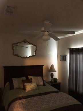 Jacksonville apartment for rent - A bedroom with a bed, a ceiling fan, and a mirror.