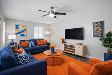 Phoenix apartment for rent - A living room with a blue couch and orange accents.