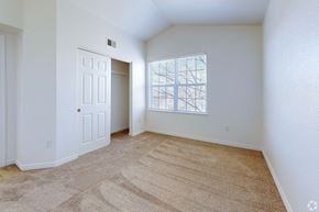 Englewood apartment for rent - A room with a carpeted floor and a window with a view of a building.