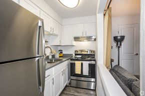 Englewood apartment for rent - A modern kitchen with a stainless steel refrigerator and a stove top oven.