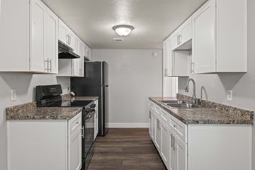 Phoenix apartment for rent - A kitchen with white cabinets and a granite countertop.