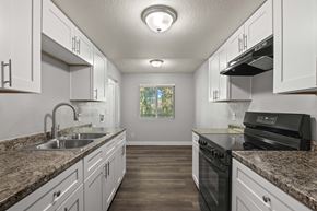 Phoenix apartment for rent - A kitchen with granite countertops and white cabinets.
