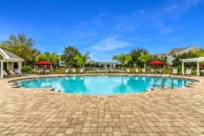 Jacksonville apartment for rent - A large outdoor swimming pool surrounded by a brick patio.
