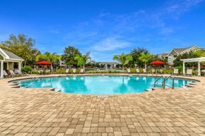 Jacksonville apartment for rent - A large outdoor swimming pool surrounded by a brick patio.