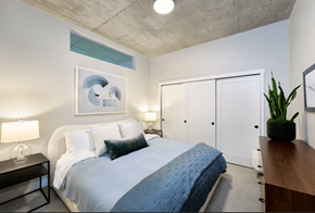 Denver apartment for rent - A bedroom with a bed, nightstand, and a plant.