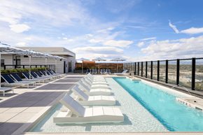 Denver apartment for rent - A pool with sun loungers and a building in the background.