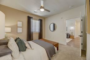 Colorado Springs apartment for rent - a bedroom with a large bed and a ceiling fan