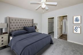 Jacksonville apartment for rent - A bedroom with a large bed and a ceiling fan.