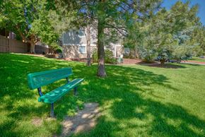 Aurora apartment for rent - a green park bench sitting in the grass