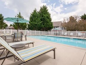 Villa Rica apartment for rent - A pool with a striped lounge chair and a table.